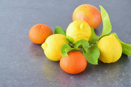 新鲜的橘子 柠檬和桔子上灰色的抽象背景。地中海的生活方式。健康的食物