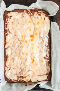 布朗尼芝士蛋糕方块在羊皮纸烘烤的窗体