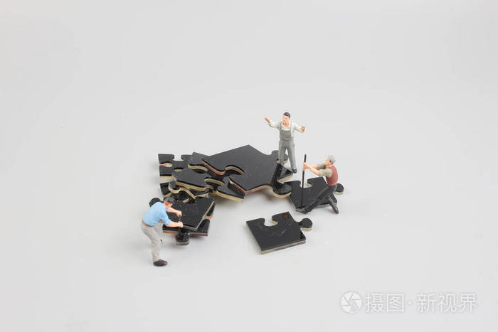 工作人员协作捧着拼图