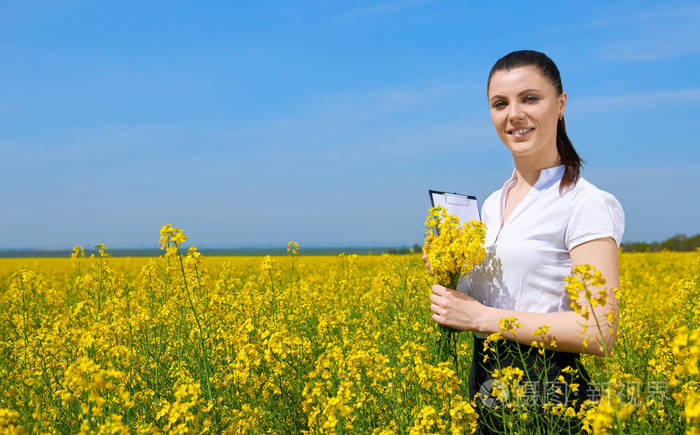 在黄色油菜花田的年轻女孩.美丽的春天景观, 阳光灿烂的日子