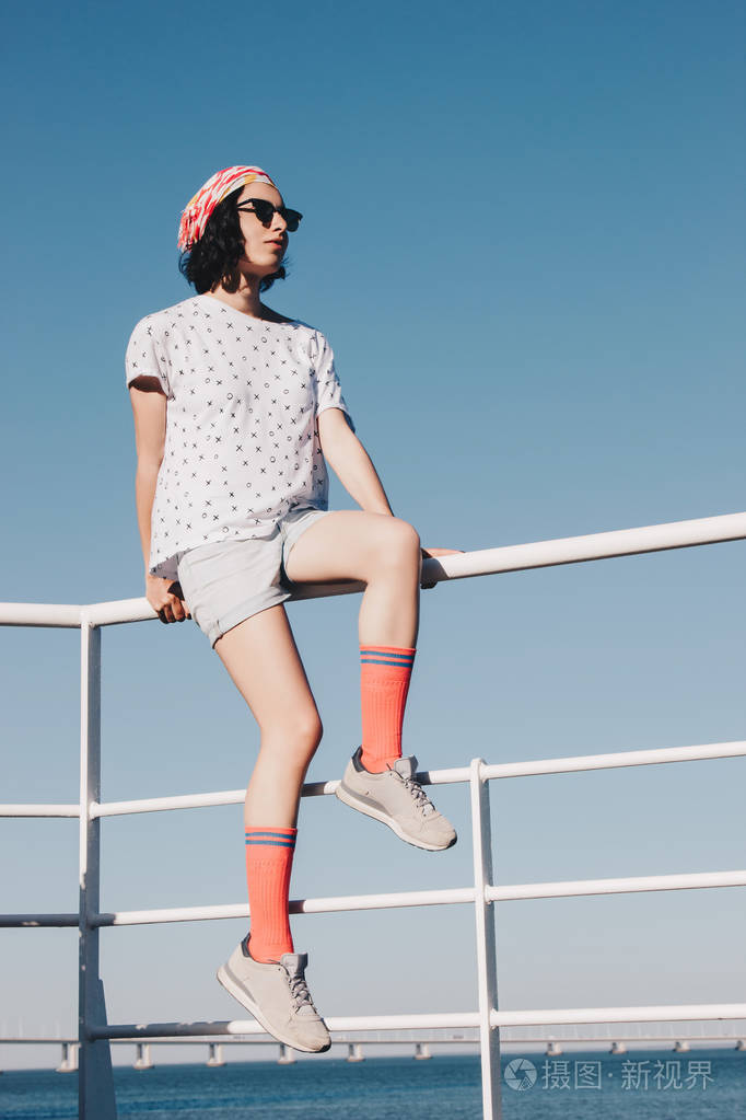 年轻女子坐在栏杆上