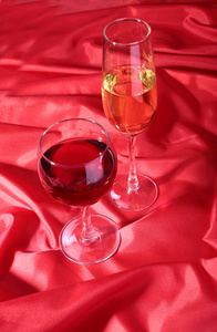 两个玻璃的红 白葡萄酒在红色背景