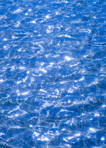 纹理背景。 纹理背景。 池中的水是在反光下拍摄的。 太阳在波浪上的眩光