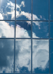 纹理图案背景。 建筑窗户的反射。 蓝色的窗户云映在窗户上