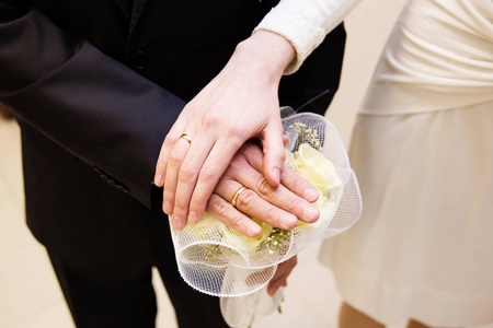 新郎和新娘戒指与新娘花束手