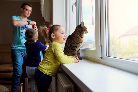 一个幸福的家庭。小女孩看着窗外背景