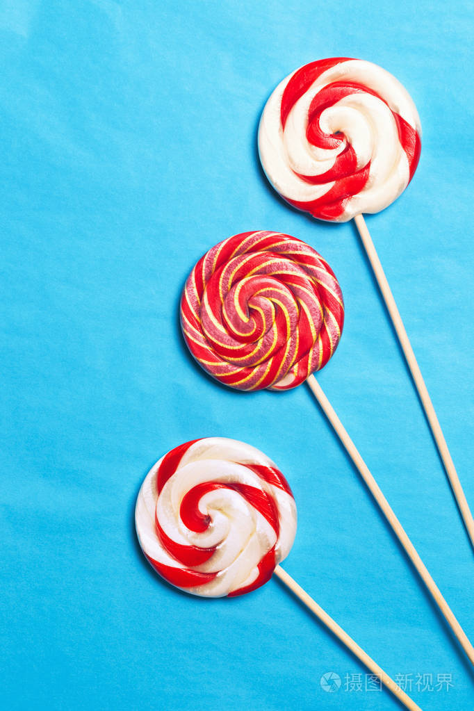 在蓝色背景上的一根棍子上的棒棒糖