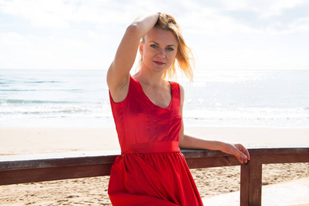金发美女在海滩的红色裙子