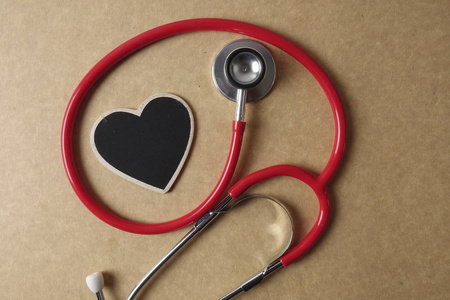 木制的背景上的红色听诊器。医疗和卫生保健的概念