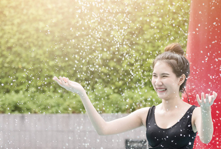 瀑布在泳池的亚洲女孩的画像。幸福