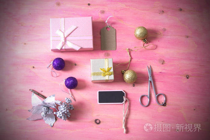 粉红色的背景上剪刀 礼品与装饰品圣诞卡圣诞