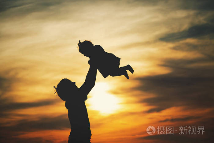 父亲和小女儿剪影发挥在日落时分