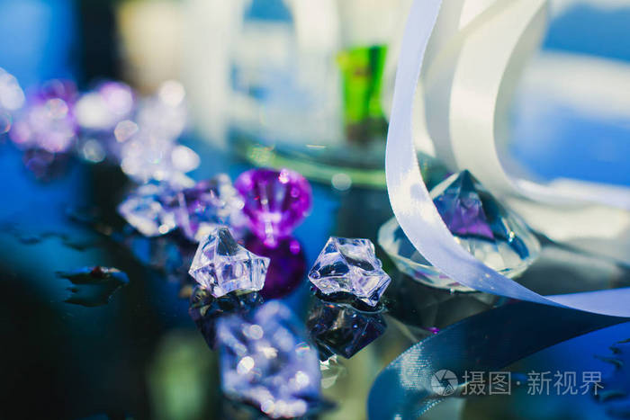 钻石小紫色宝石宝石堆在镜子玻璃桌上水晶石头闪亮的黄金和银色珠宝在