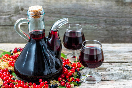 旧的葡萄酒瓶，木制的桌子上。制成的甜醇水果很多品种浆果醋栗