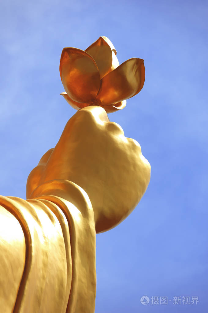 金佛像手捧花在蓝天上