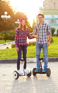 年轻夫妇骑飞翔器是电动滑板车，个人的电子商务