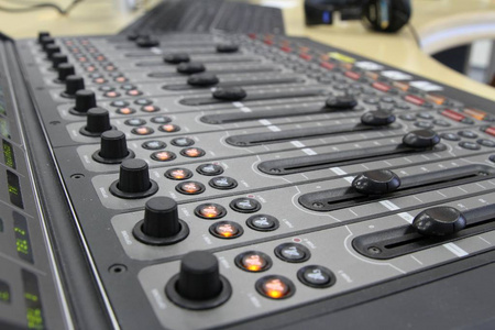 专业音频操作员工作音频混音器旋钮在实况电视转播