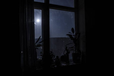 从黑暗的房间透过窗户看到的月亮夜景