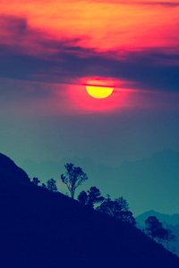 夕阳在山，与风景秀丽的日落太阳在色彩斑斓的天空背景树剪影