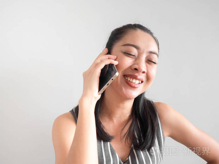 微笑和快乐的亚洲女人在智能手机上打电话.