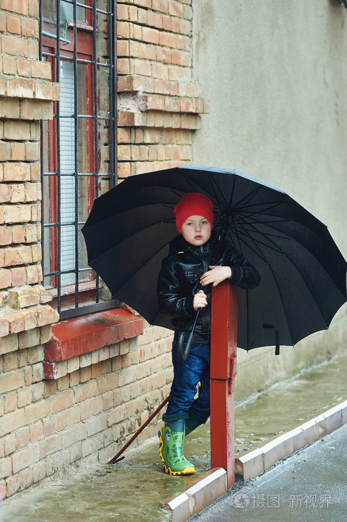 男孩抱着这把伞走在雨中的春天