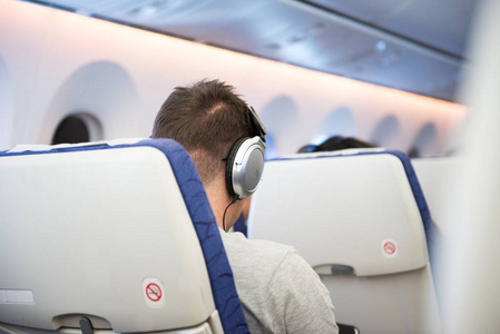 耳机坐在飞机同时出国旅行的人图片