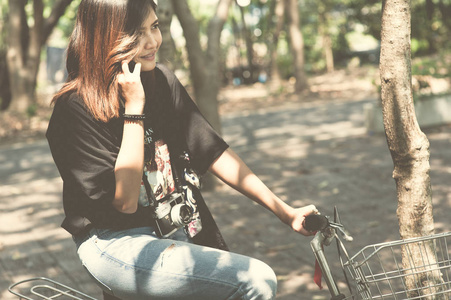 浅谈手机在公园里的一辆自行车上的漂亮女孩