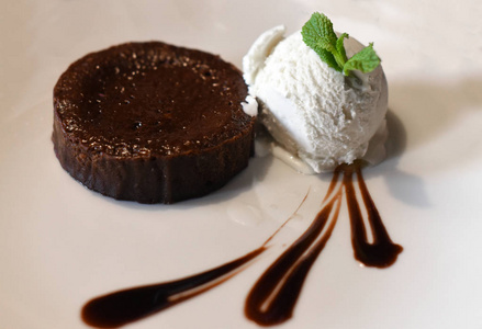 在白板上香草冰淇淋球一个巧克力软糖蛋糕装饰用液体巧克力