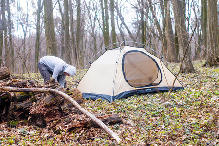 年轻人在树林里放一个帐篷