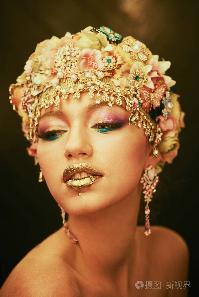 发型和化妆金耳环美女与金妆黄金皮肤化妆头发和黑色背景上的珠宝时尚