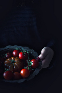 女人抱着旧的乡村板块充分的西红柿