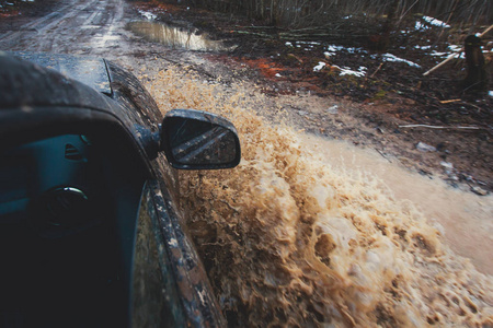 4wd 越野车骑着马穿过泥泞的水坑里，越野轨道路，溅起的水花，在 jeeping 竞争