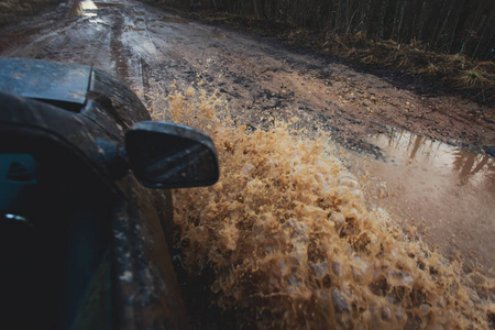 4wd 越野车骑着马穿过泥泞的水坑里，越野轨道路，溅起的水花，在 jeeping 竞争