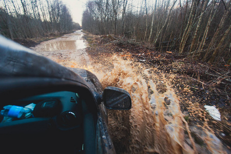 4wd 越野车骑着马穿过泥泞的水坑里，越野轨道路，溅起的水花，在 jeeping 竞争