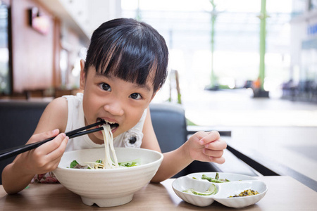 亚洲中国小女孩吃牛肉粉丝汤