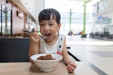 亚洲中国小女孩吃红烧猪肉饭图片