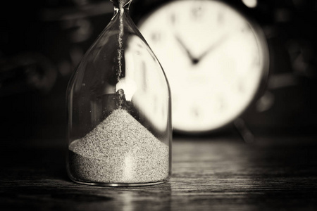 在木材上黑板在木材与黑板背景上的沙漏照片