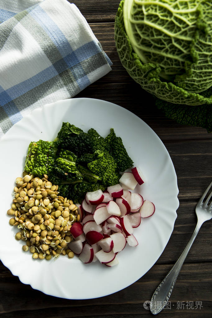 白菜, 萝卜芽和小扁豆在白板上的 rawfoodist 纯素食沙拉愉悦