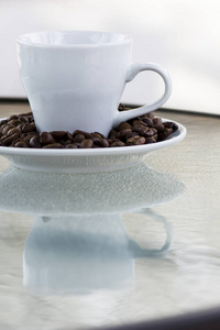 浓缩咖啡。关于飞碟和一个小的白色杯子咖啡豆