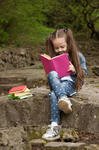 一个女孩正在读一本书用放大镜。聪明的小 p