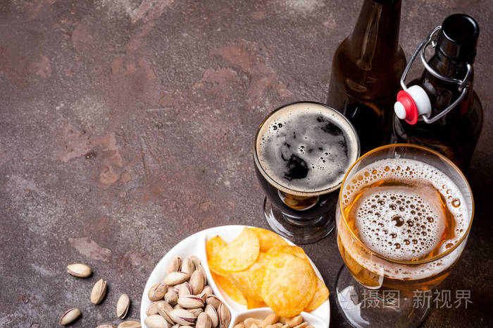 照片 在具体的桌子上的瓶子和眼镜特写的啤酒.