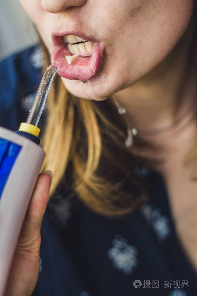 一个女人在浴室中使用口腔冲洗器