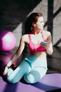 在健身房使用智能手机的女人
