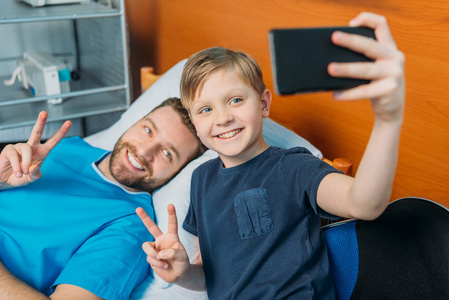 父亲和儿子在病房采取自拍照