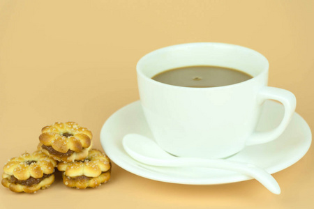咖啡杯和咖啡豆在橙色背景下。