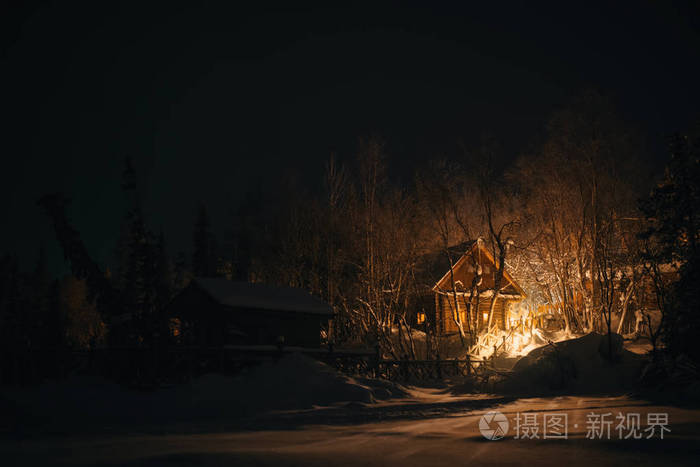 白雪皑皑的丛林,在冬天的夜晚间木房子里