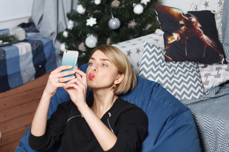 拍照墙年轻美丽的商业女性使自拍照手机白色墙壁上照片