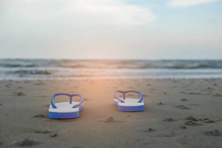 旅游概念，与海洋背景下海滩上的鞋子
