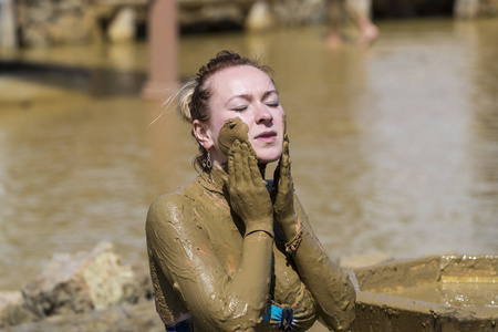 年轻女孩洗泥浴以改善皮肤状况照片