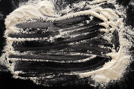 烘焙概念在黑色背景上的，撒上面粉与副本空间